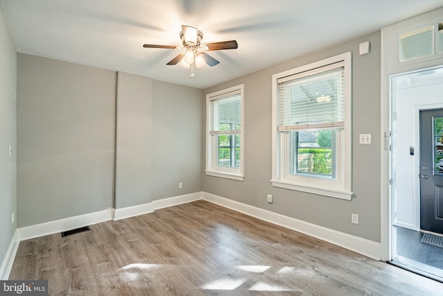 unfurnished room featuring wood finished floors, ceiling fan, and baseboards