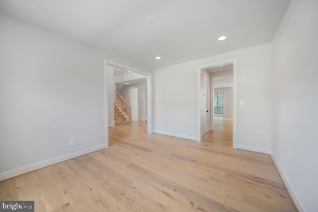 spare room featuring light wood-style floors, baseboards, and recessed lighting