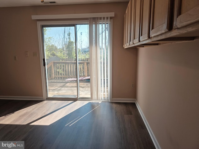 doorway featuring visible vents, baseboards, a healthy amount of sunlight, and dark wood-style flooring