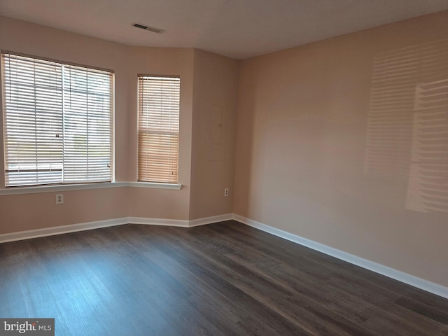 unfurnished room with dark wood finished floors, baseboards, and visible vents