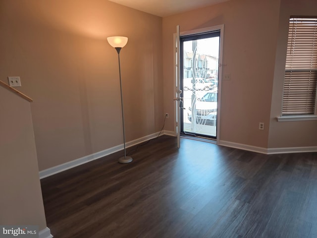 spare room featuring wood finished floors and baseboards