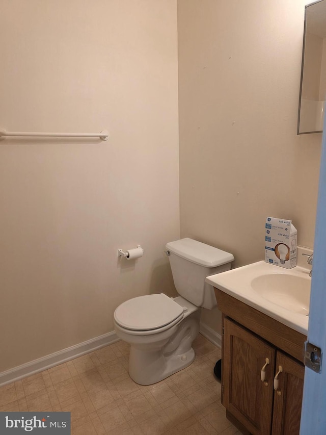 bathroom with baseboards, toilet, vanity, and tile patterned floors