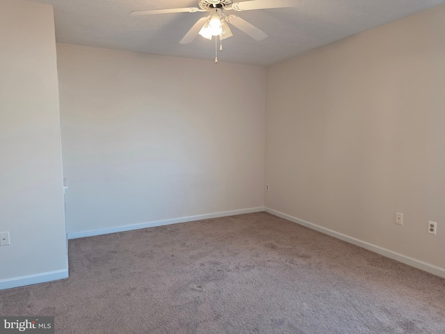 carpeted empty room featuring baseboards and ceiling fan