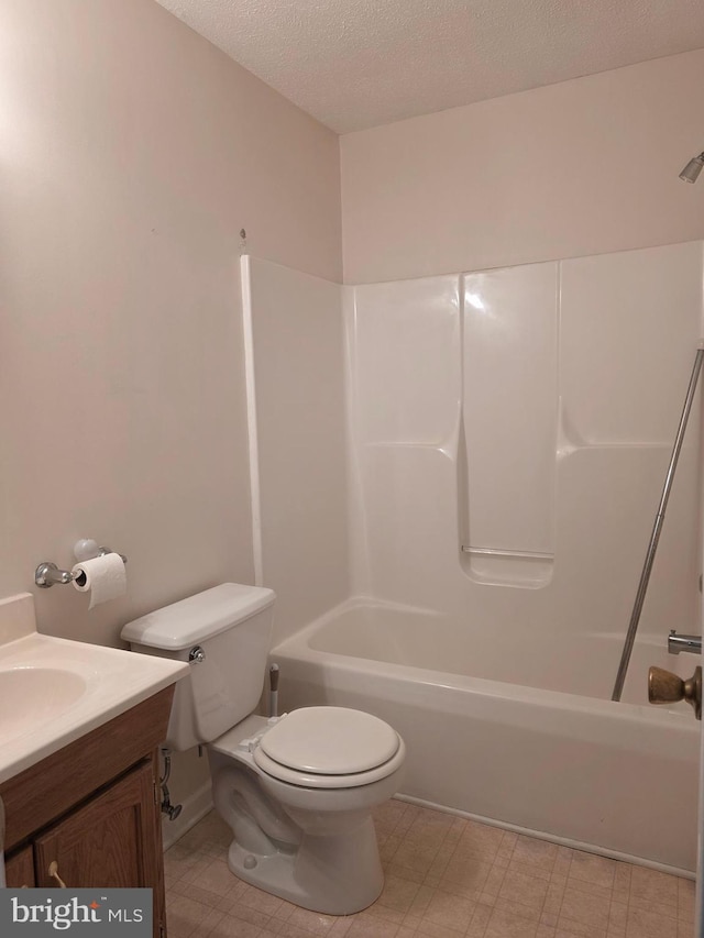 full bath with a textured ceiling, toilet, vanity, and shower / tub combination