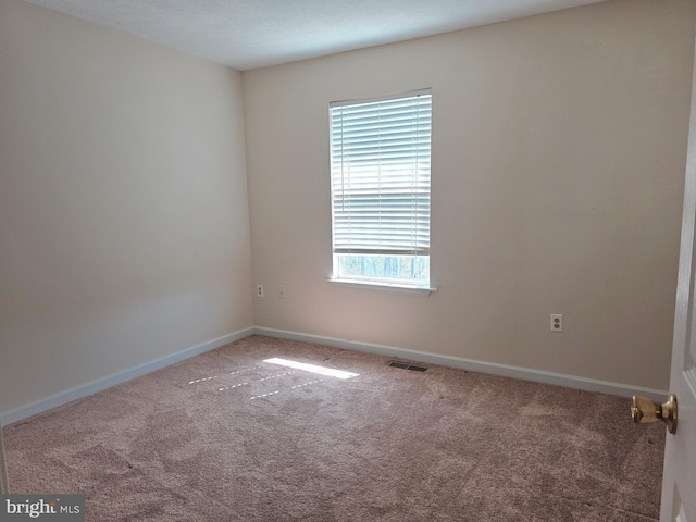 carpeted empty room with baseboards and visible vents