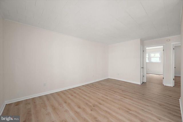 12505 Assawoman Dr, Ocean City, MD 21842 - empty room with light wood finished floors, baseboards, and crown molding