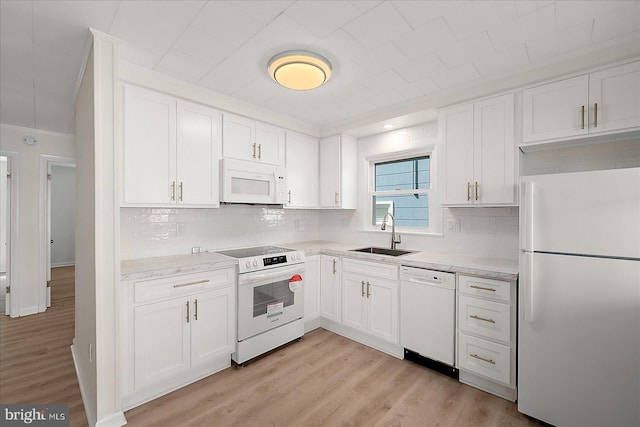 12505 Assawoman Dr, Ocean City, MD 21842 - kitchen with white cabinets, a sink, white appliances, light wood-style floors, and crown molding