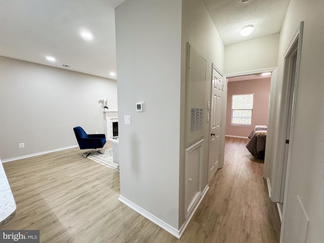 corridor with baseboards and wood finished floors