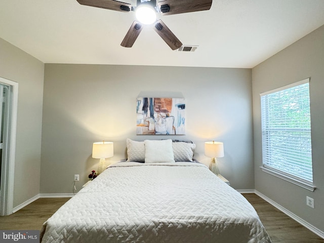 bedroom with baseboards, visible vents, dark wood-style floors, and ceiling fan