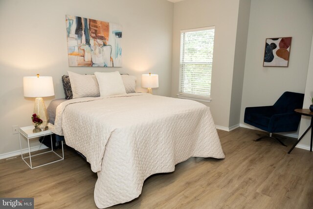 bedroom with baseboards and wood finished floors
