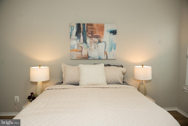 bedroom featuring wood finished floors and baseboards