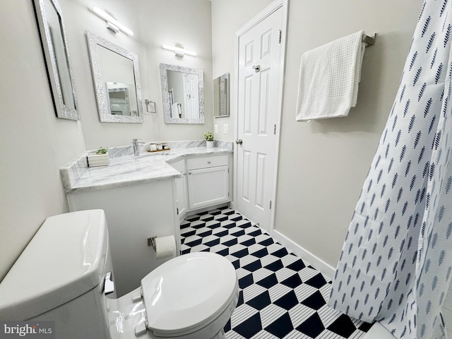 bathroom with tile patterned floors, vanity, a shower with curtain, baseboards, and toilet