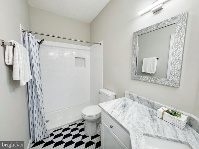 bathroom featuring a tile shower, toilet, vanity, and tile patterned floors