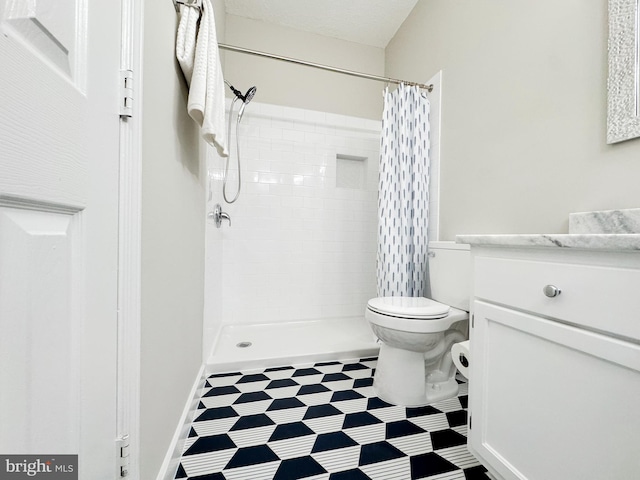 full bath with a tile shower, toilet, vanity, and tile patterned floors
