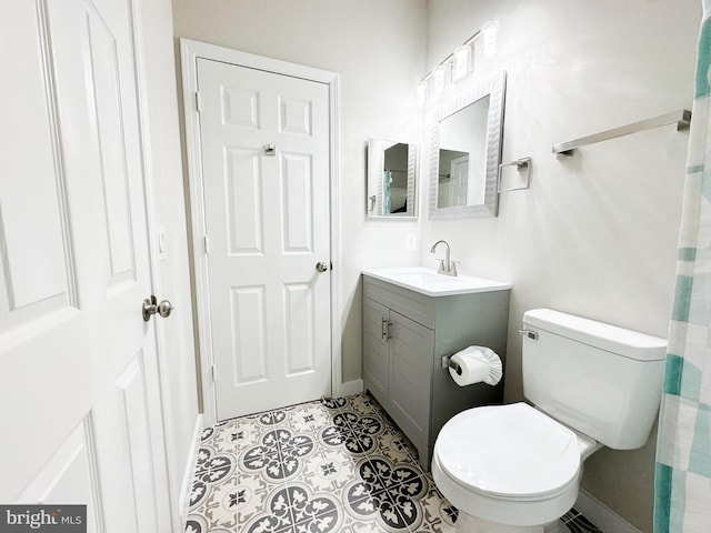 bathroom with vanity, toilet, and baseboards