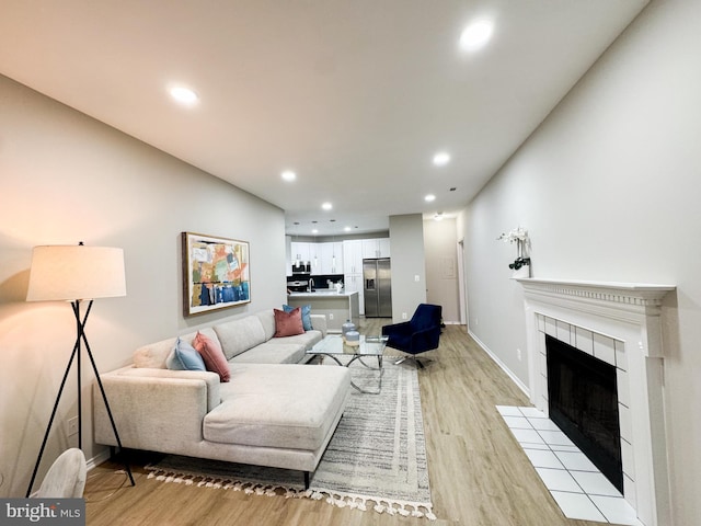 living room with a fireplace, baseboards, light wood finished floors, and recessed lighting