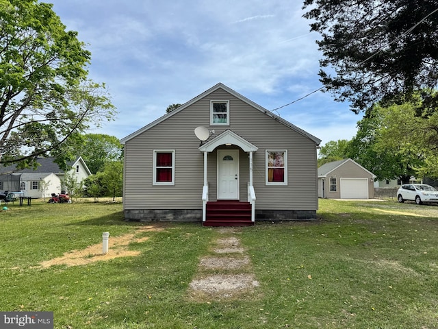 bungalow with a detached garage and a front yard