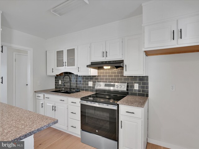 kitchen featuring white cabinets, under cabinet range hood, backsplash, a sink, and electric range