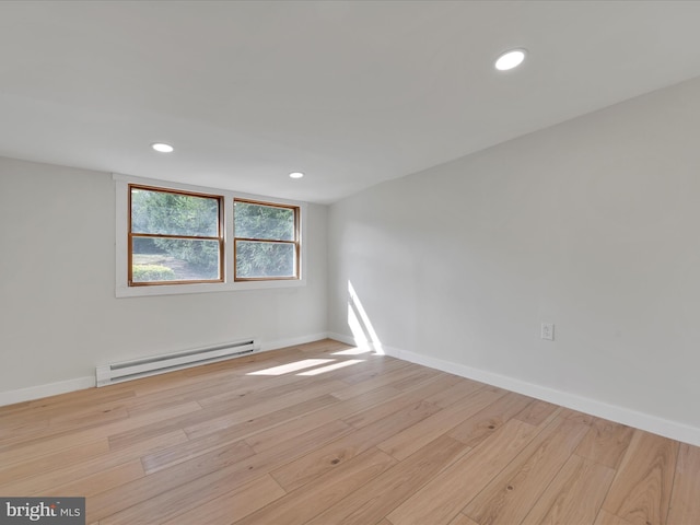 unfurnished room with a baseboard heating unit, light wood finished floors, baseboards, and recessed lighting