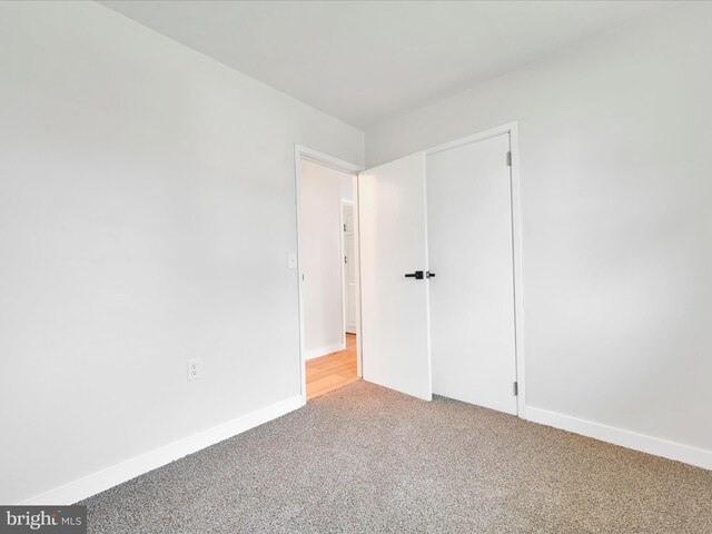 unfurnished bedroom with light carpet and baseboards