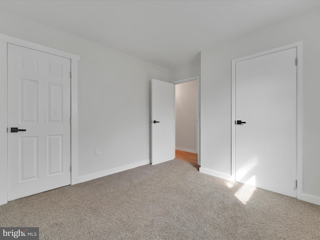 unfurnished bedroom with baseboards and carpet