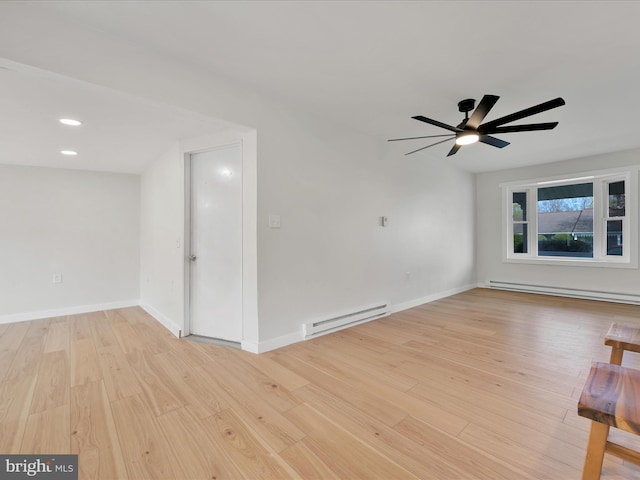 unfurnished living room with a baseboard heating unit, ceiling fan, baseboards, and light wood-type flooring
