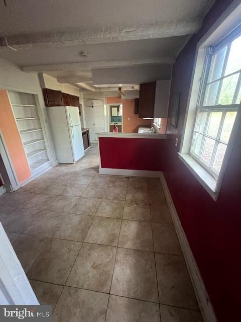 18506 Triangle St, Triangle, VA 22172 - kitchen featuring freestanding refrigerator, a peninsula, baseboards, light tile patterned floors, and beamed ceiling