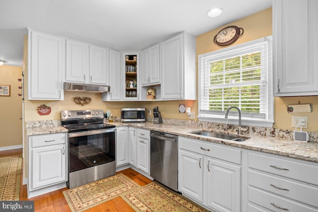 202 Stern Cv, Stafford, VA 22554 - kitchen with appliances with stainless steel finishes, a sink, under cabinet range hood, white cabinetry, and light stone counters