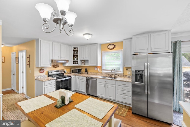 202 Stern Cv, Stafford, VA 22554 - kitchen featuring appliances with stainless steel finishes, a sink, a chandelier, under cabinet range hood, and glass insert cabinets