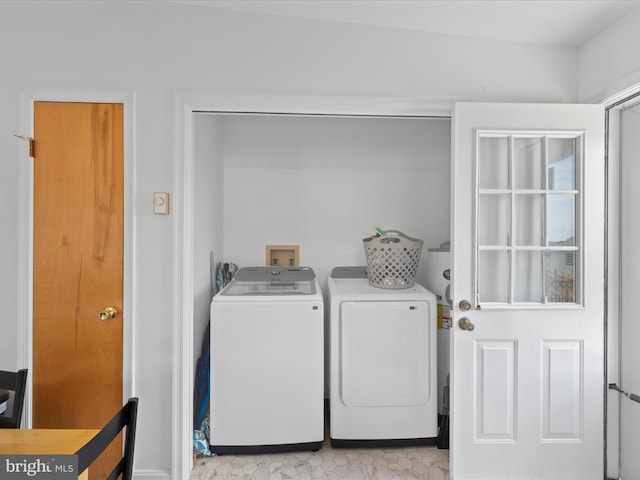 washroom featuring washing machine and clothes dryer, laundry area, and baseboards