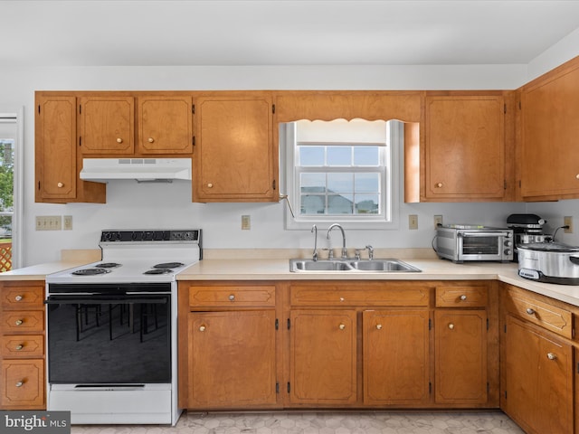 kitchen featuring a sink, light countertops, under cabinet range hood, a toaster, and electric range oven