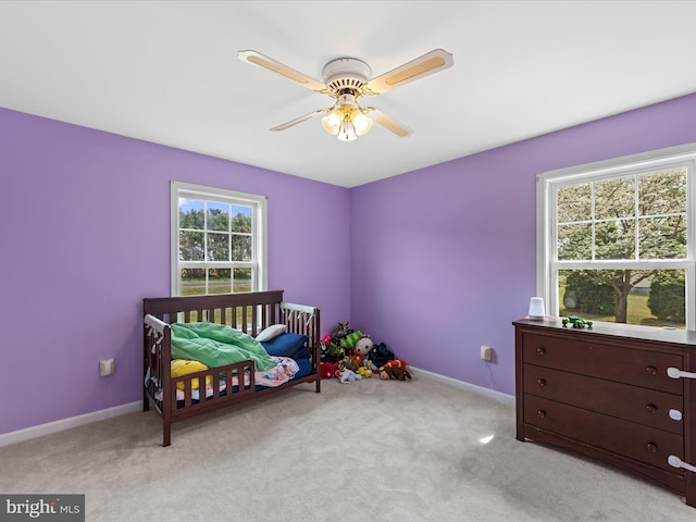 carpeted bedroom with ceiling fan and baseboards