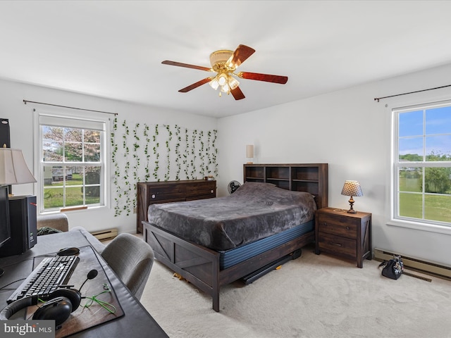 carpeted bedroom featuring a baseboard heating unit, multiple windows, and ceiling fan