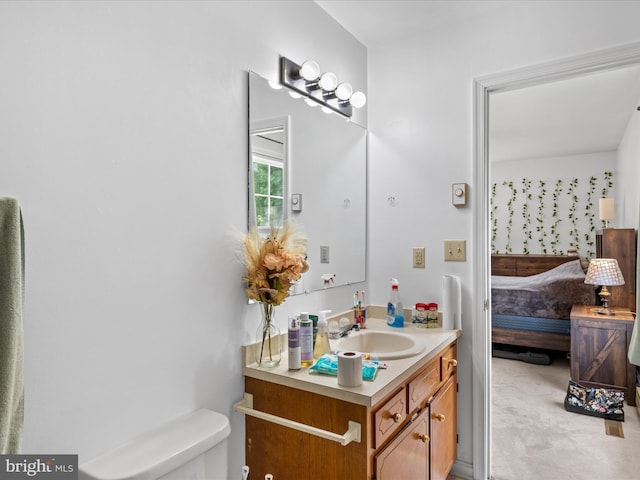 bathroom with vanity, toilet, and ensuite bathroom