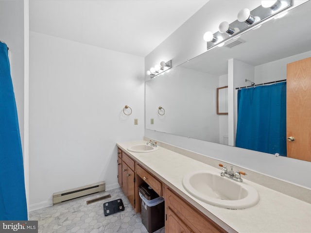 full bath featuring a baseboard heating unit, double vanity, a sink, and baseboards