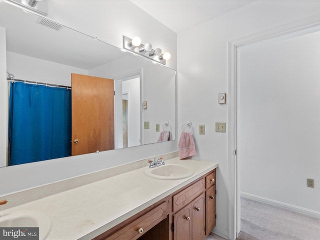 full bath featuring visible vents, curtained shower, double vanity, and a sink