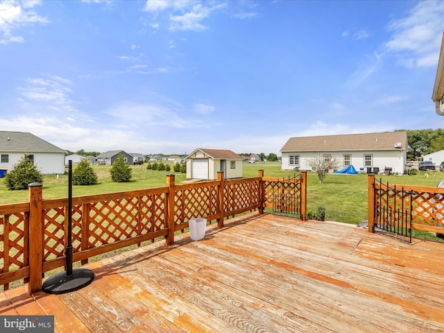 deck featuring a lawn, an outdoor structure, a residential view, and a garage