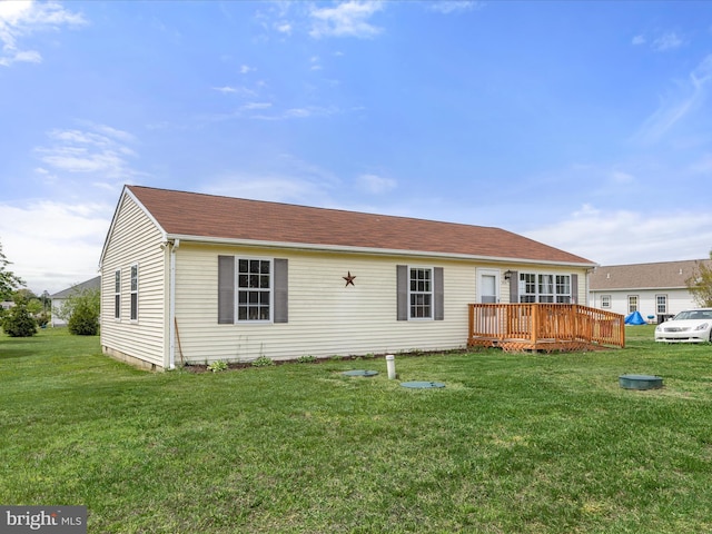 back of property with a deck and a yard