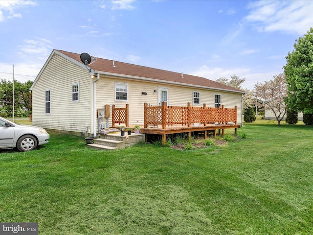rear view of property featuring a deck and a lawn