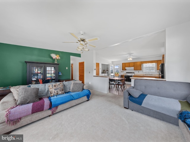 living area with a ceiling fan and light carpet