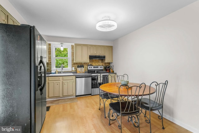 kitchen featuring a sink, light wood-style flooring, under cabinet range hood, and stainless steel appliances