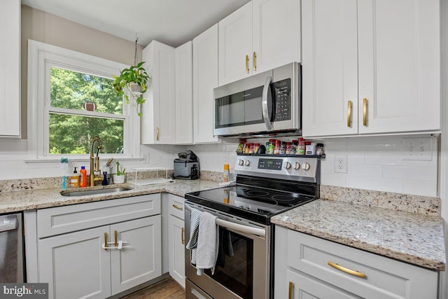 23745 Hicks Dr, Leonardtown, MD 20650 - kitchen featuring appliances with stainless steel finishes, a sink, white cabinetry, and tasteful backsplash