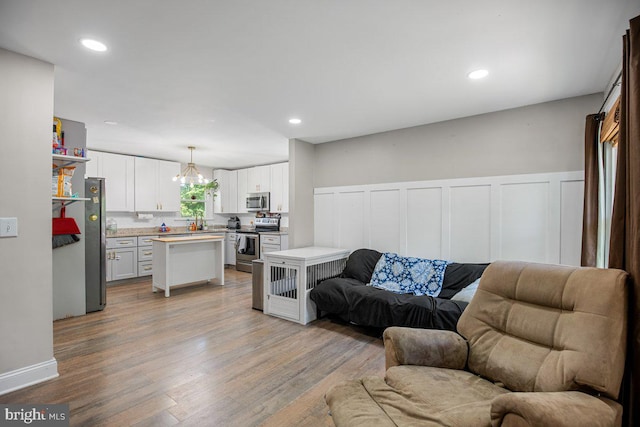 23745 Hicks Dr, Leonardtown, MD 20650 - living area with light wood-style floors, wainscoting, a chandelier, a decorative wall, and recessed lighting
