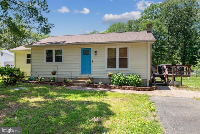 23745 Hicks Dr, Leonardtown, MD 20650 - bungalow featuring entry steps, a chimney, a front yard, and a wooden deck