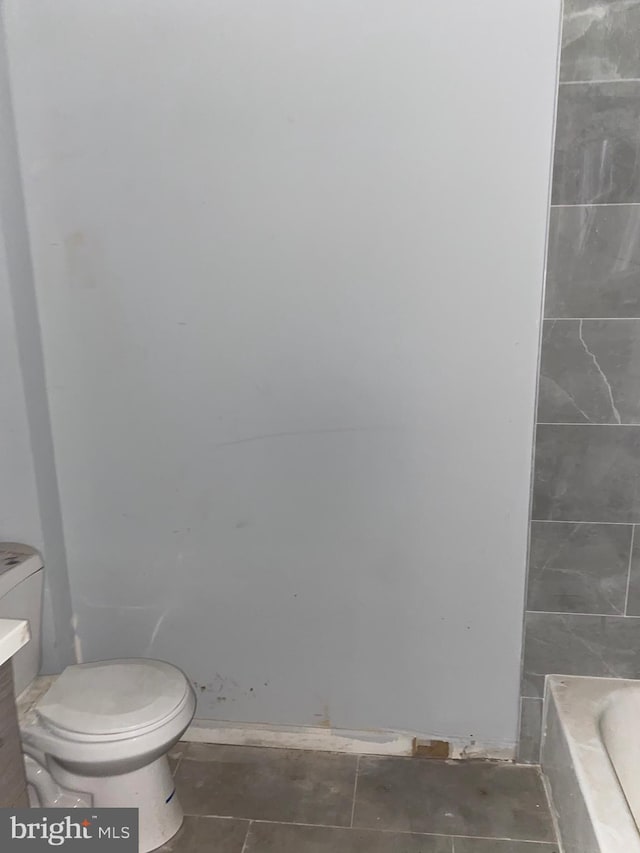 full bathroom with a washtub, toilet, and vanity