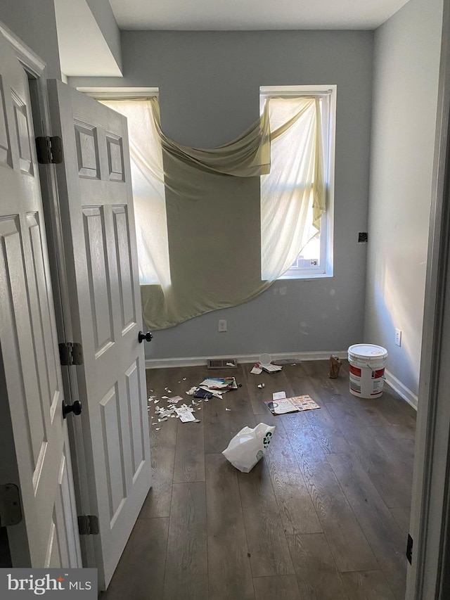 unfurnished bedroom featuring hardwood / wood-style floors and baseboards