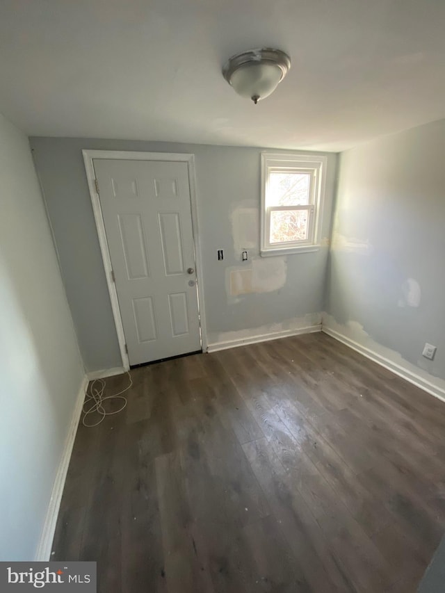 entrance foyer featuring baseboards and dark wood finished floors