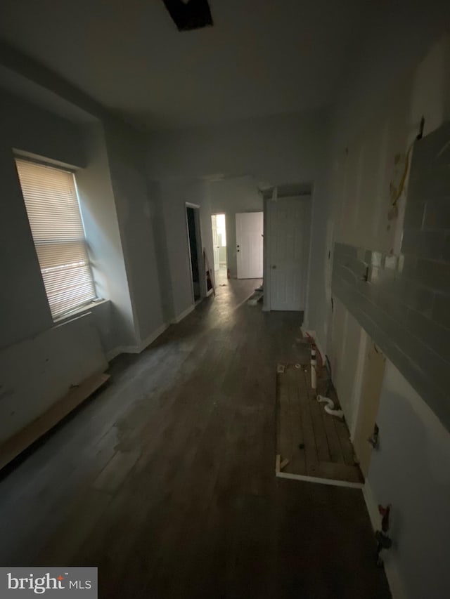 interior space with dark wood-type flooring and baseboards