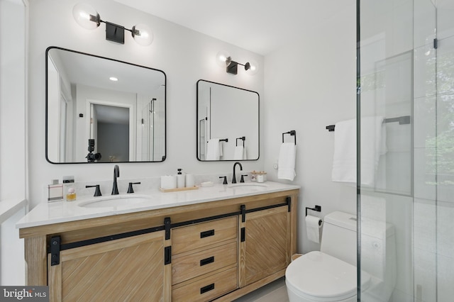 bathroom featuring double vanity, toilet, a sink, and a shower with shower door
