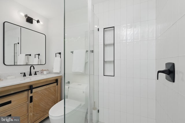full bathroom featuring toilet, tiled shower, and vanity